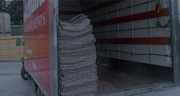 Chargement de cartons et d’emballages dans un camion de déménagement prêt à partir, prêt pour la checklist déménagement.